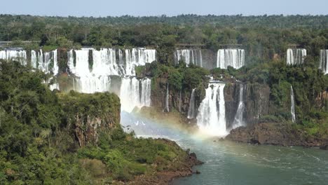 虹彩在伊瓜祖瀑布 (iguazu falls) 上延伸,其中有一座宏伟的瀑布