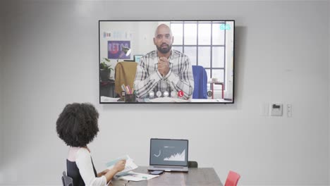 African-american-businesswoman-on-video-call-with-african-american-male-colleague-on-screen