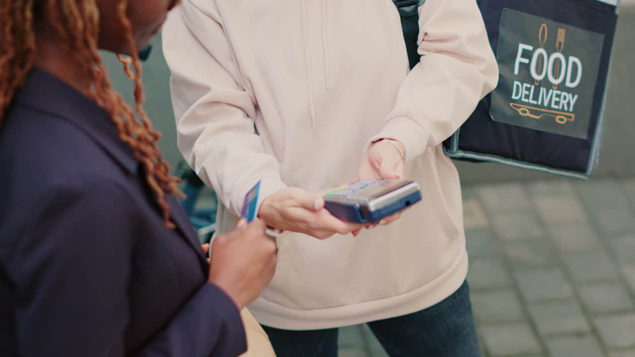 A woman paying for a food delivery with her credit card