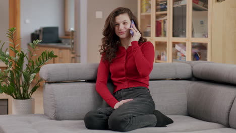 pretty caucasian girl in red cardigan on sofa - animated phone call, living room