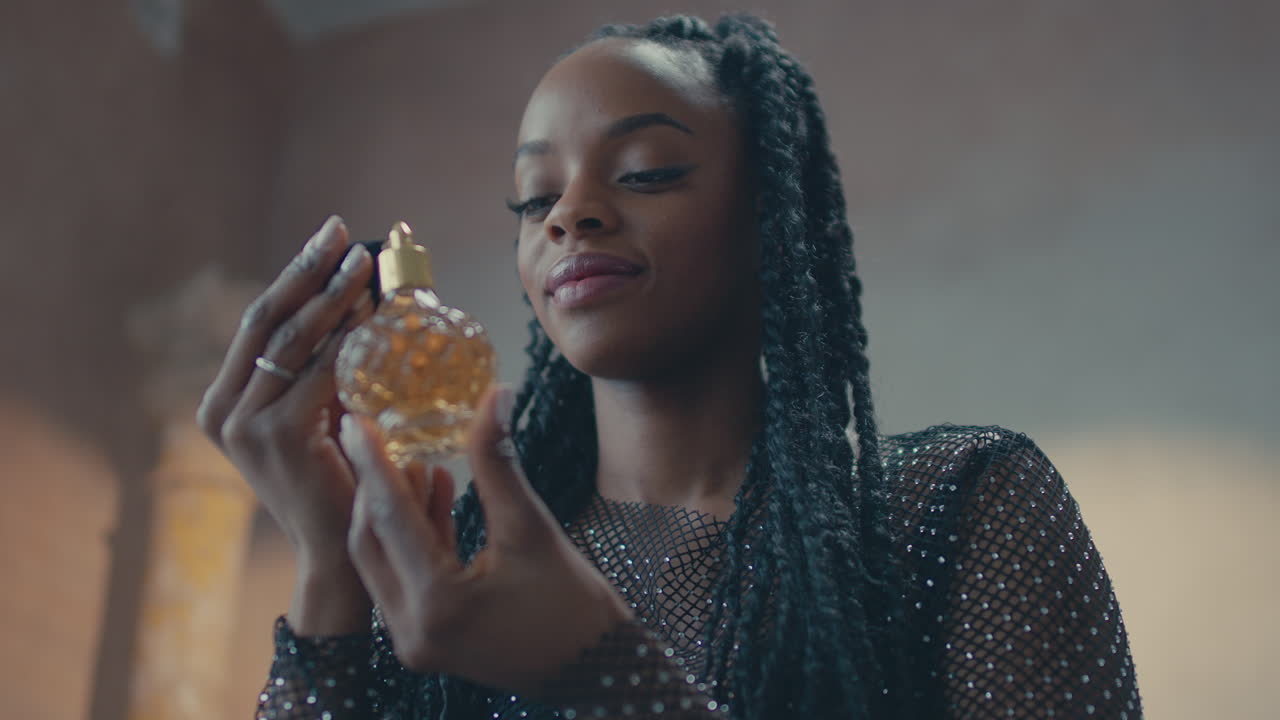 Ripresa al rallentatore di una modella africana che si applica il profumo