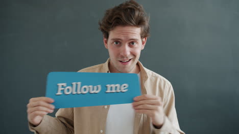 man holding a sign saying 'follow me'