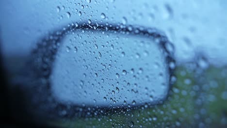 gotas de lluvia en la ventana del asiento del pasajero con espejo durante el mal tiempo, tire del foco