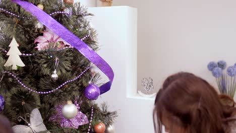 dos chicas jóvenes decoran el árbol de navidad