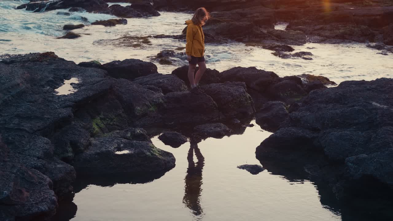 Windy Shoreline Sunset – Japanese Ocean Scene
Evening sun lights up clouds and waves while a woman looks to sea, still and serene on rugged coastal rocks.
