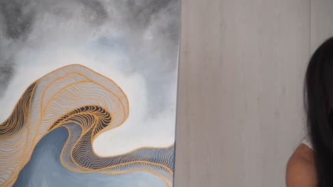niña hispana cepillando pintura en el costado del lienzo mientras habla