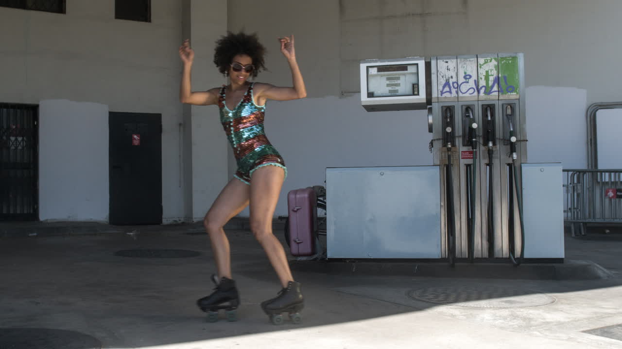 mujer de patinaje sobre ruedas baila y patina afuera en un entorno urbano