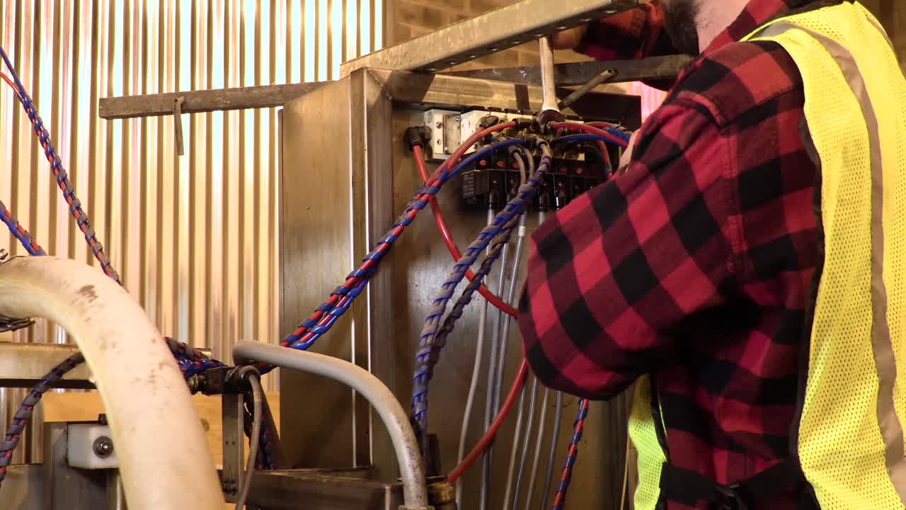 Blue Collar Worker in a Safety Vest Working on Heavy Machinery