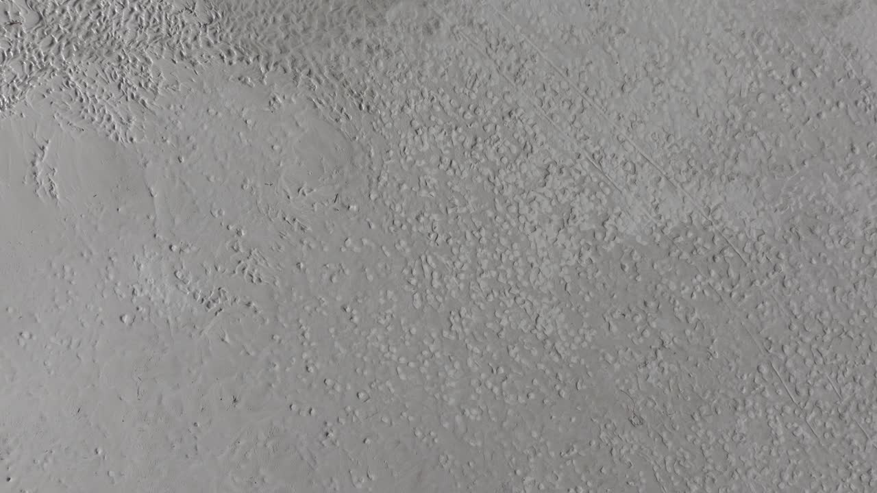 movimiento aéreo hacia arriba y órbita de pasos en la arena del gran lago salado, utah en un día soleado