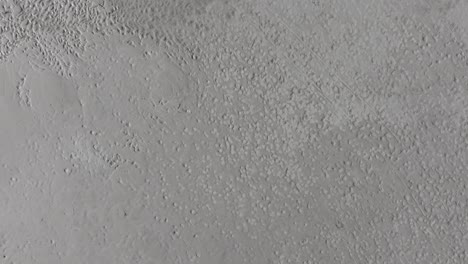 aerial upward and orbit movement of footsteps on the sand of the great salt lake, utah on a sunny day