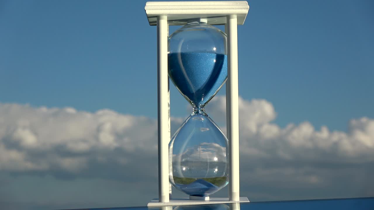 reloj de arena en el fondo del cielo y movimiento de arena azul