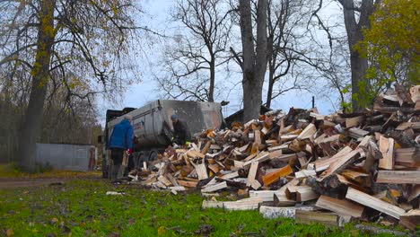 men unloading firewood from a truck