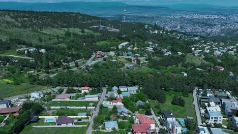 Drohnenaufnahme-Der-Naturseite-Von-Tiflis-Mit-Vielen-Wunderschönen-Grünen-Bäumen-Und-Klarem-Himmel