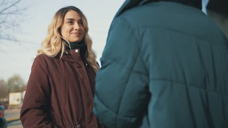 female friends hugging and talking in the city