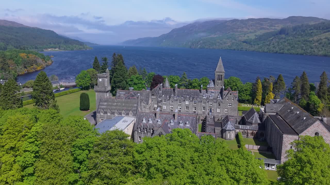 Drone footage revealing the historic Highland Club, a former abbey turned luxury resort, with the stunning Loch Ness and Scottish Highlands in the background