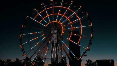 statue of ali and nino on a background ferris wheel at night on the embankment of batumi, georgia