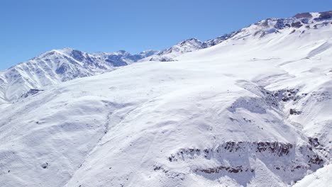 Panoramic-aerial-view-of-the-snow-capped-Andes-mountain-range-on-a-sunny-day,-Chile