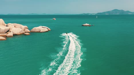 Toma-Aérea-De-Drones-De-Una-Pareja-De-Jet-Ski-Navegando-A-Alta-Velocidad-En-Una-Bahía-Tropical-Exótica-Con-Mar-Esmeralda