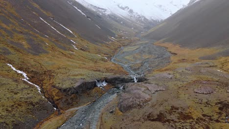 Skutafoss-waterfall-glacier-valley-wedged-between-high-snowy-mountains