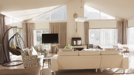 panning shot of furnished living room home interior with large sunny windows, slow motion