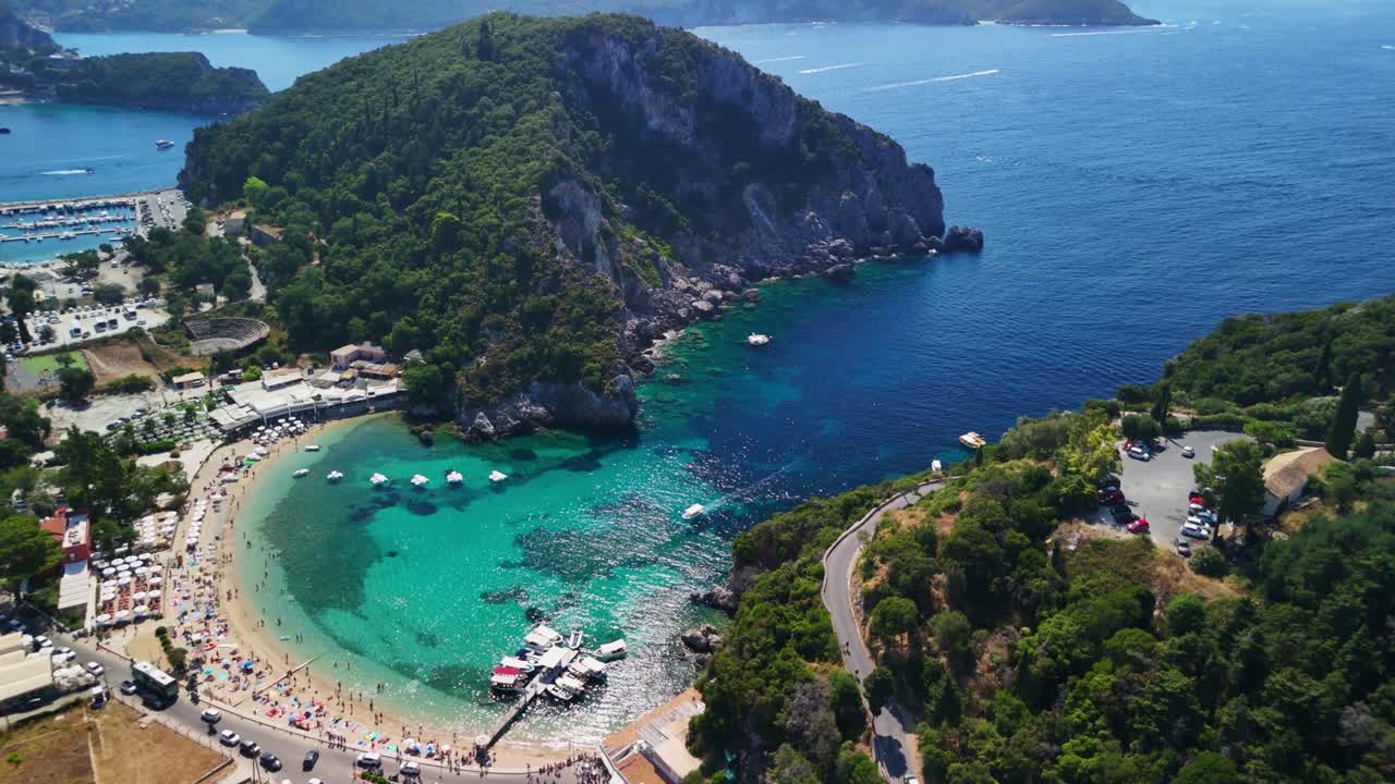 Aerial view of a vibrant coastal bay with clear blue water and lush hills