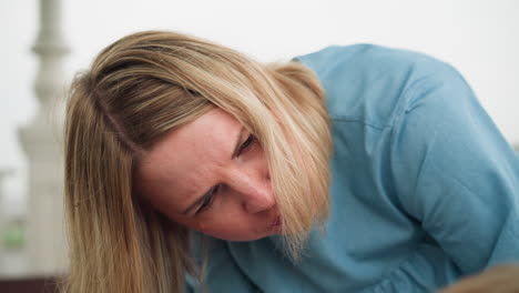 a woman leans forward with a concentrated expression, addressing someone partially visible in the background