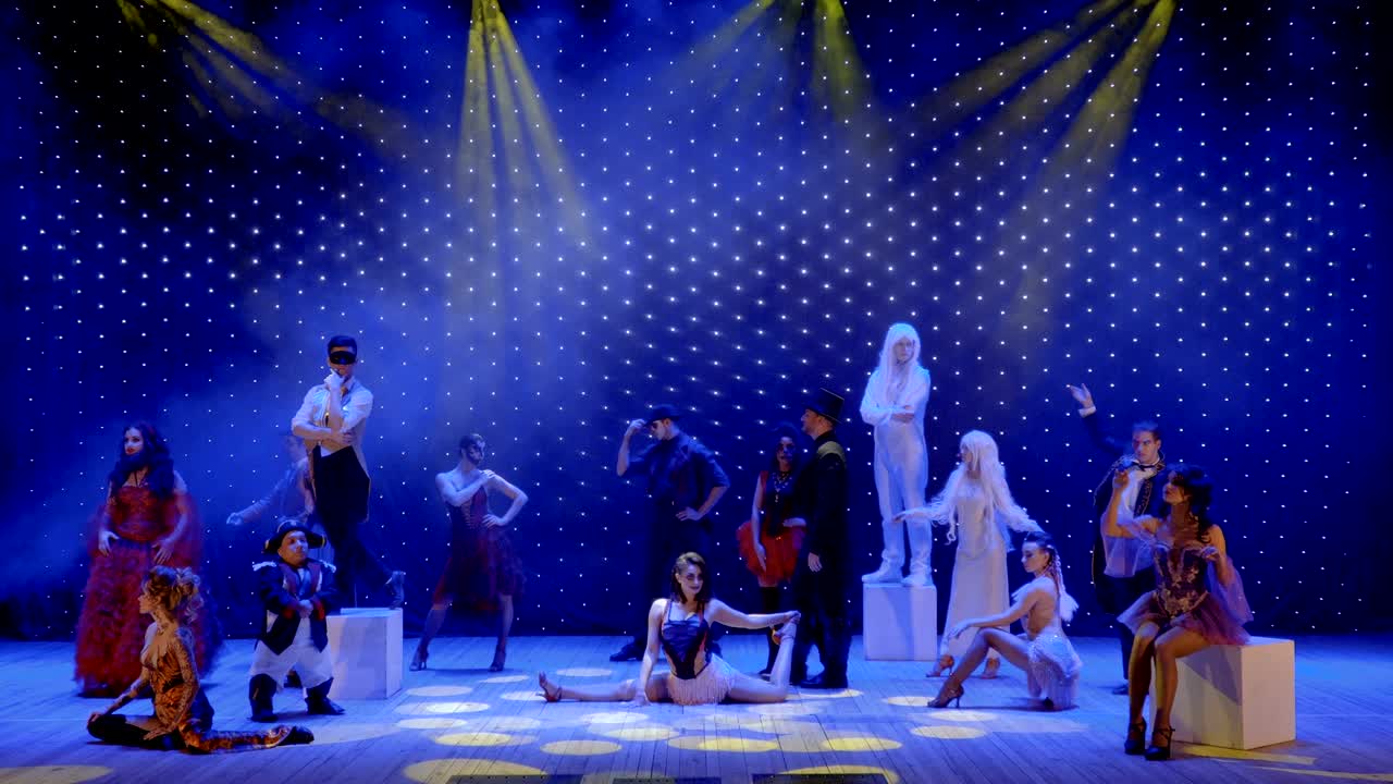 In love couple walks between people and sings love song on the stage in theatre