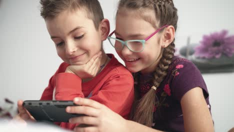 happy kids watching cartoon on smartphone. children looking at mobile phone