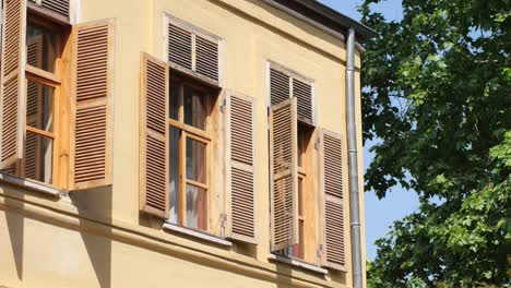 close up of a yellow building with wooden shutters on the windows