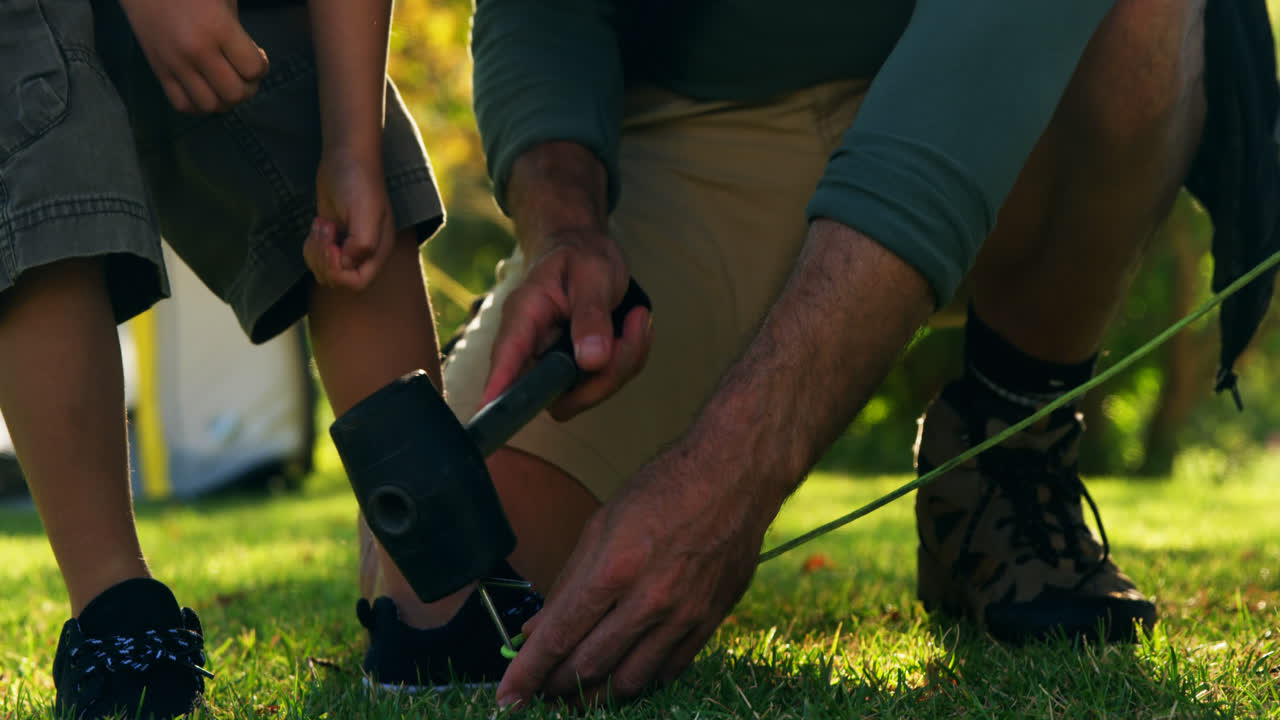 아버지 와 아들 이 텐트 를 세우고 있다