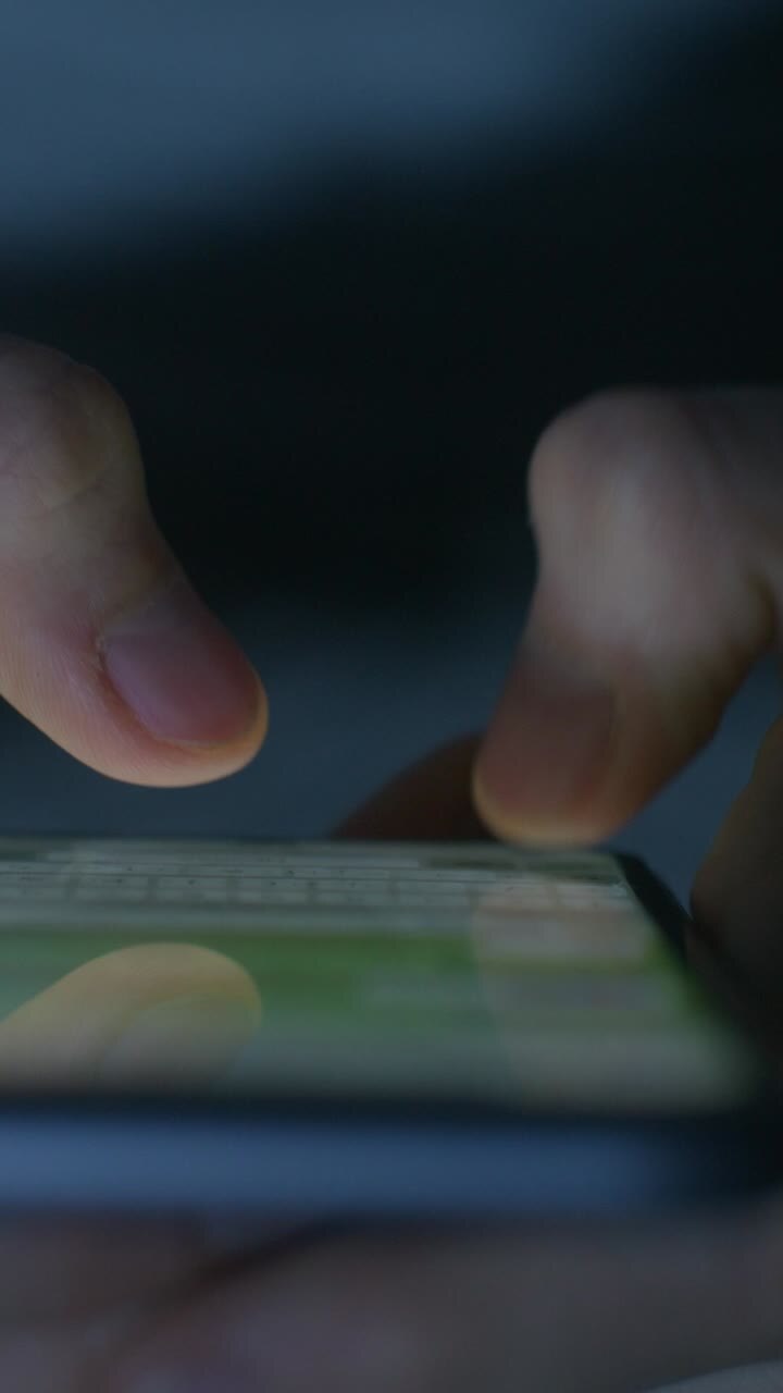 Close up of hands using a smartphone at night