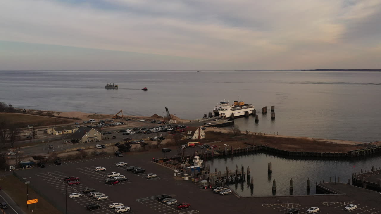 снимок с воздуха: паром "ориент-пойнт" причаливает к причалу, принимая автомобили и пассажиров для следующего рейса