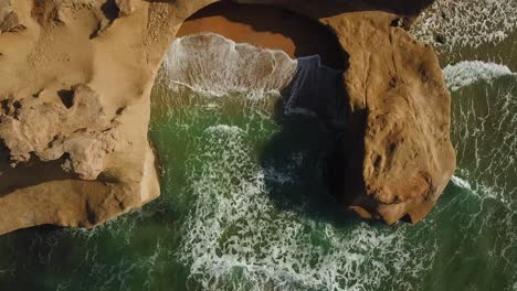 Smooth-rock-erosion-circle-round-coastal-cave-hidden-private-beach-seaside-campsite-camping-in-sea-sand-marine-corridor-green-color-water-wave-and-wonderful-scenic-natural-landscape-Arabian-Gulf-iran