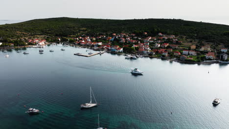 el seguimiento de drones sigue a la lancha de velocidad que sale del canal fuera de la isla de ilovik, croacia.