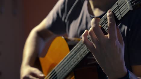 joven tocando guitarra clásica centrándose en técnicas avanzadas de digitación con la mano izquierda