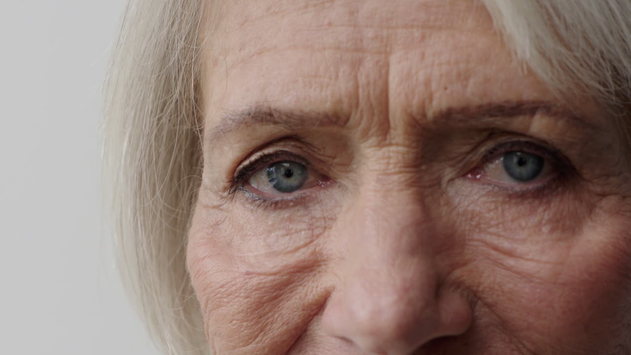 mujer mayor de cerca hermosos ojos azules gira la cabeza mirando a la cámara belleza humana