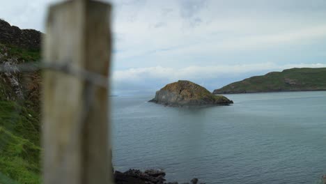 deslizador de mano más allá de la valla de alambre de púas a la isla frente a la costa de las tierras altas de escocia