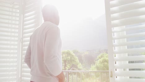 thoughtful african american senior man looking outside window