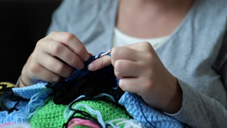 woman's hands knitting handmade crochet clothes from wool yarn