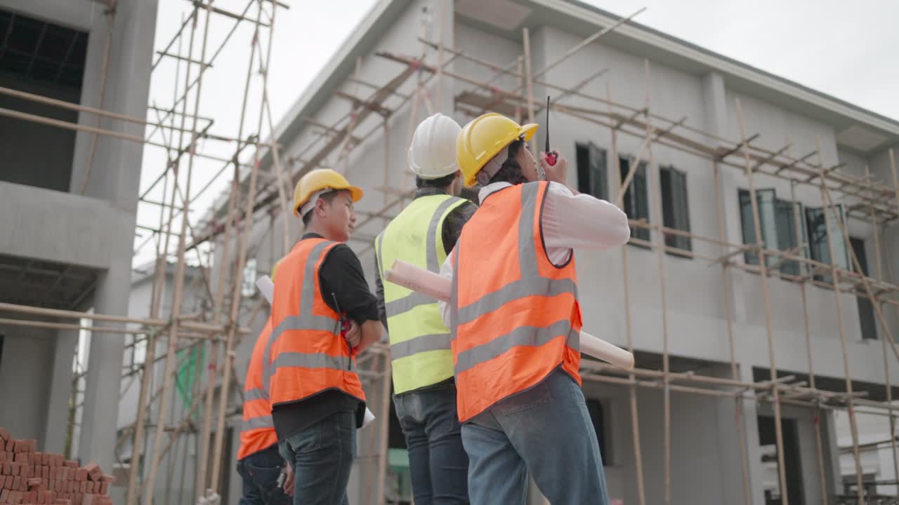 Back view. Grouo of professional contractor and foreman or worker working together in construction sites. Team civil engineer supervise construction at housing project. Concept of real estate business.