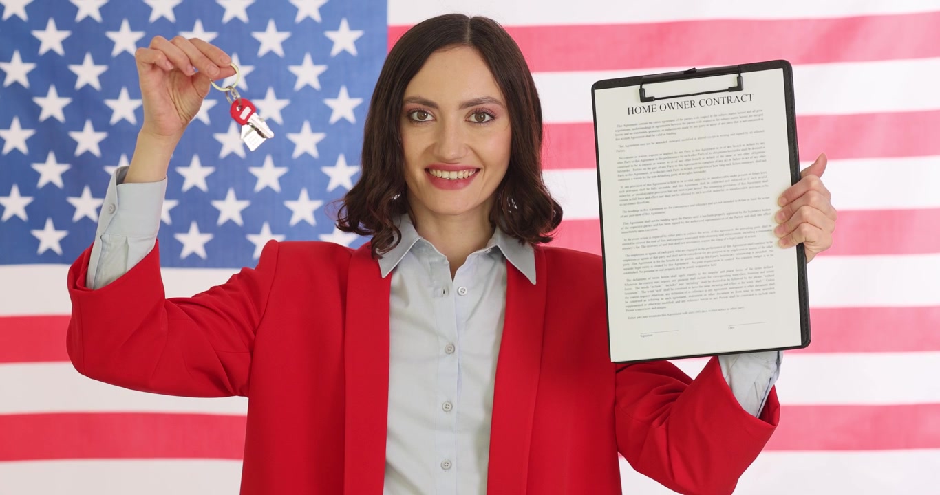 Woman holds up key to flat with document on clipboard in hands