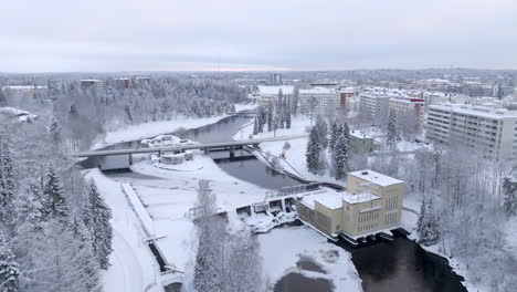 aerial ascending shot in front of the snowy ammakoski dam and the kajaani castle