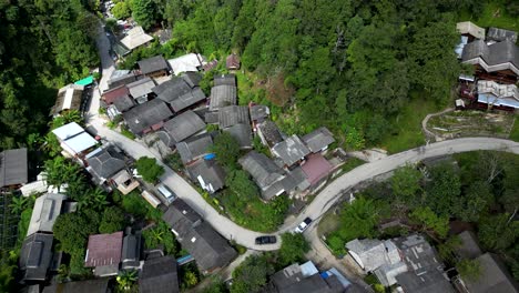 slow cinematic tilt up over winding road in traditional thai village mae kampong