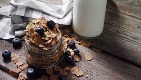 jar filled with wheat flakes and blueberries 4k