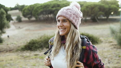 Happy-hiking-girl-wearing-woolen-hat-and-backpack