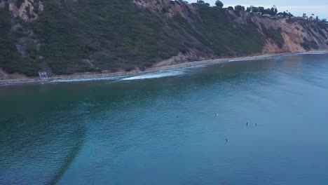 los surfistas esperan en sus longboards para atrapar una ola y montarla en la orilla - vista aérea cerca del rancho palos verdes