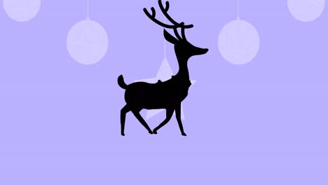 silueta negra de renos caminando sobre las decoraciones colgantes de navidad contra un fondo púrpura