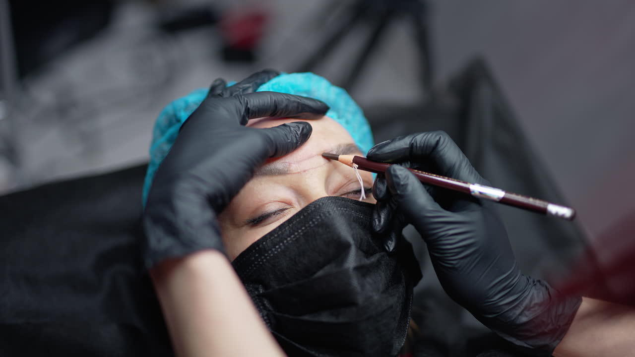 Cosmetologist draws eyebrows. The cosmetologist prepares to make eyebrow tattoo