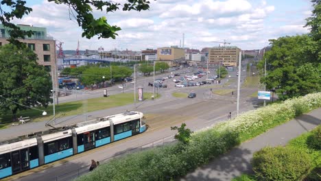 blue and white trams passing by in gothenburg seen from hill
