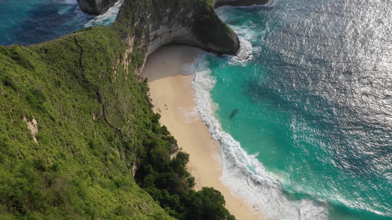 olas espumosas blancas del mar esmeralda salpicando en la playa de arena kelingking